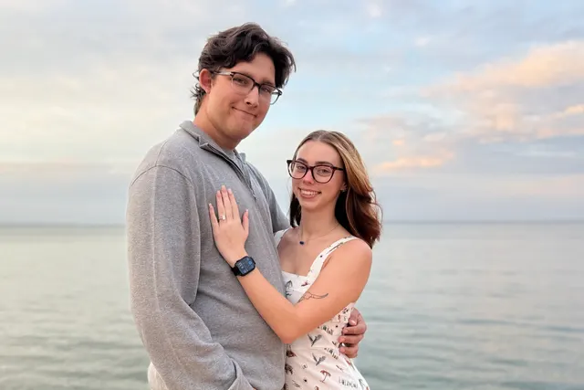 Mason Slaughter and his fiancee standing by the water at sunset on the Emerald Coast.